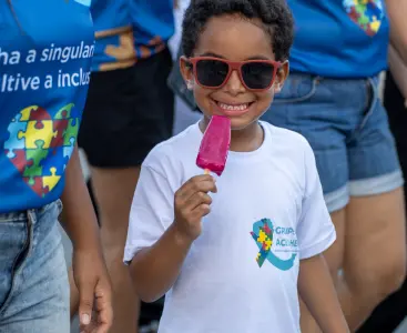 Foto de uma criança sorrindo em evento da Acolher