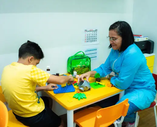 Foto de uma criança brincando com um terapeuta